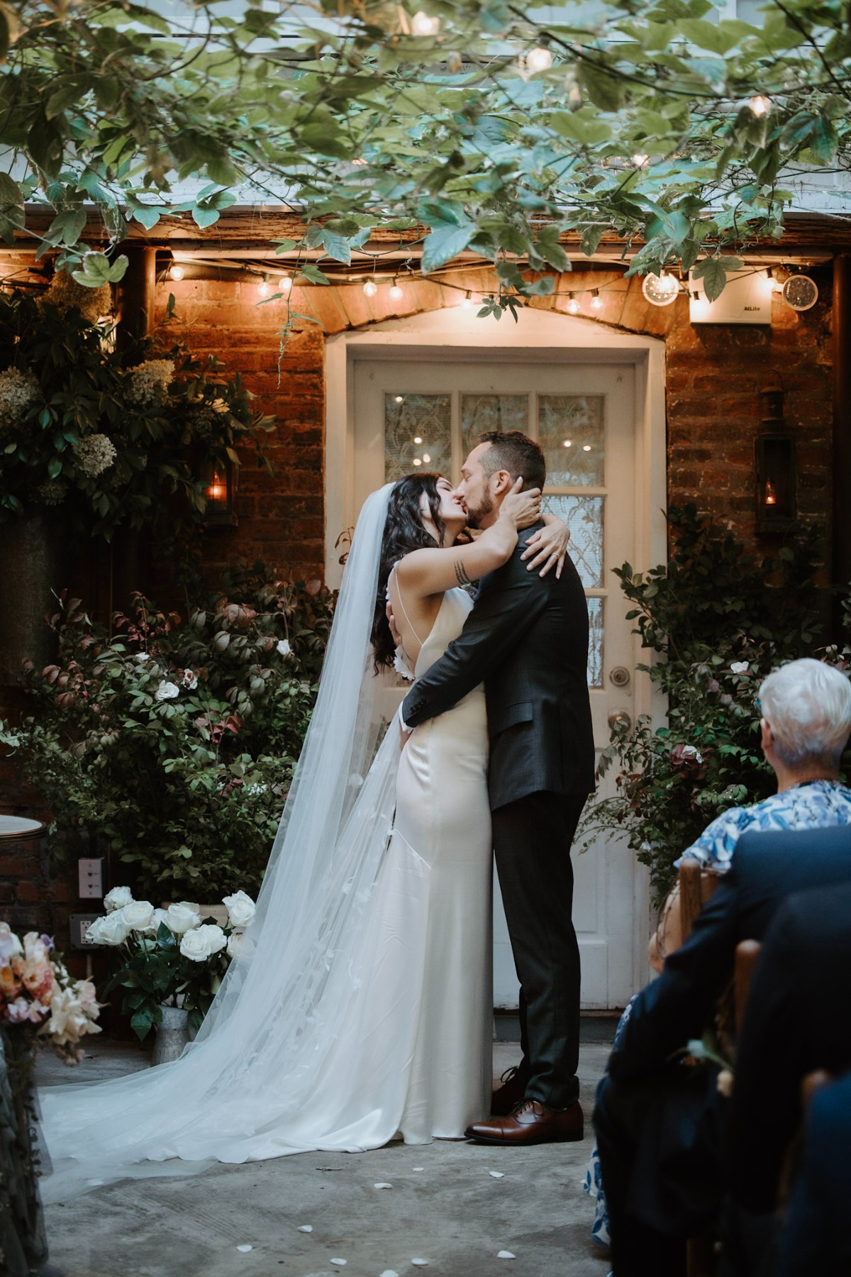 ivy covered patio for wedding ceremony with buckets of roses