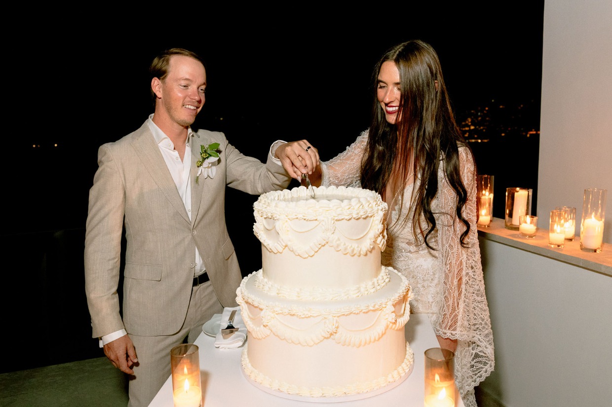 bride cuts wedding cake in galia lahav dress