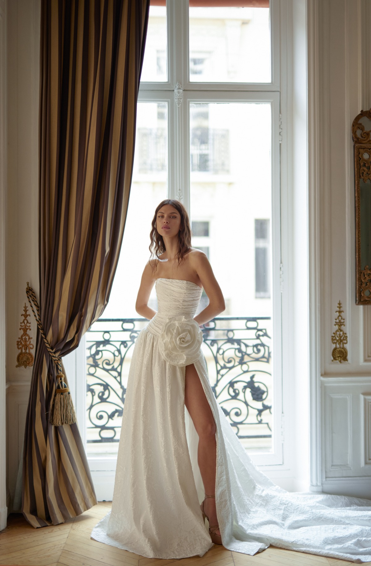bride wearing strapless wedding dress with big white flower on hip and leg slit
