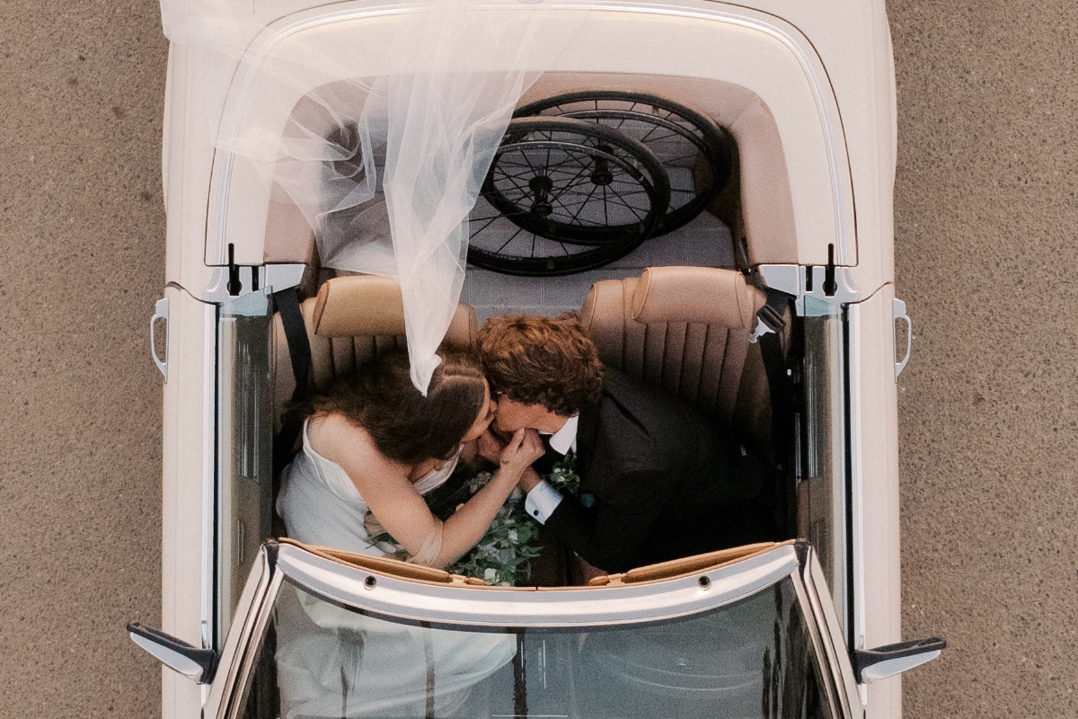 bride and groom in vintage convertible car