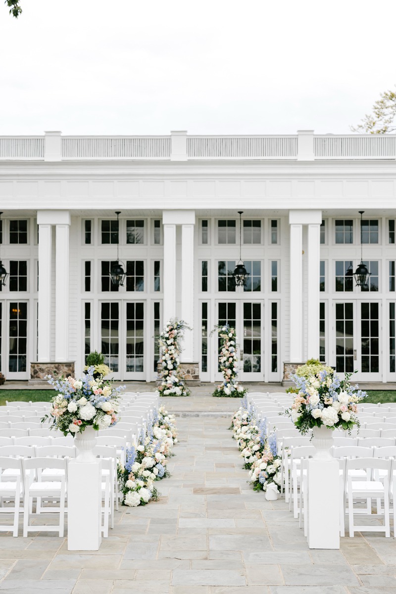 blue white and peach wedding ceremony floral arrangements