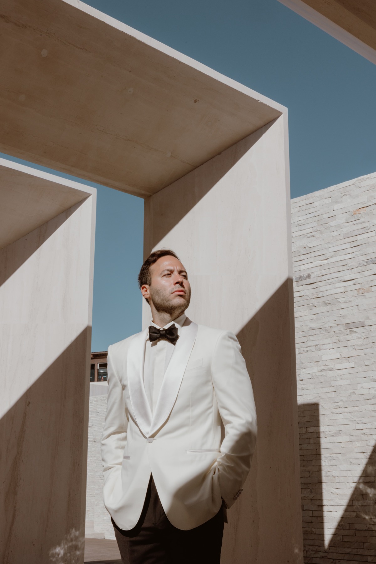 groom in white tuxedo jacket