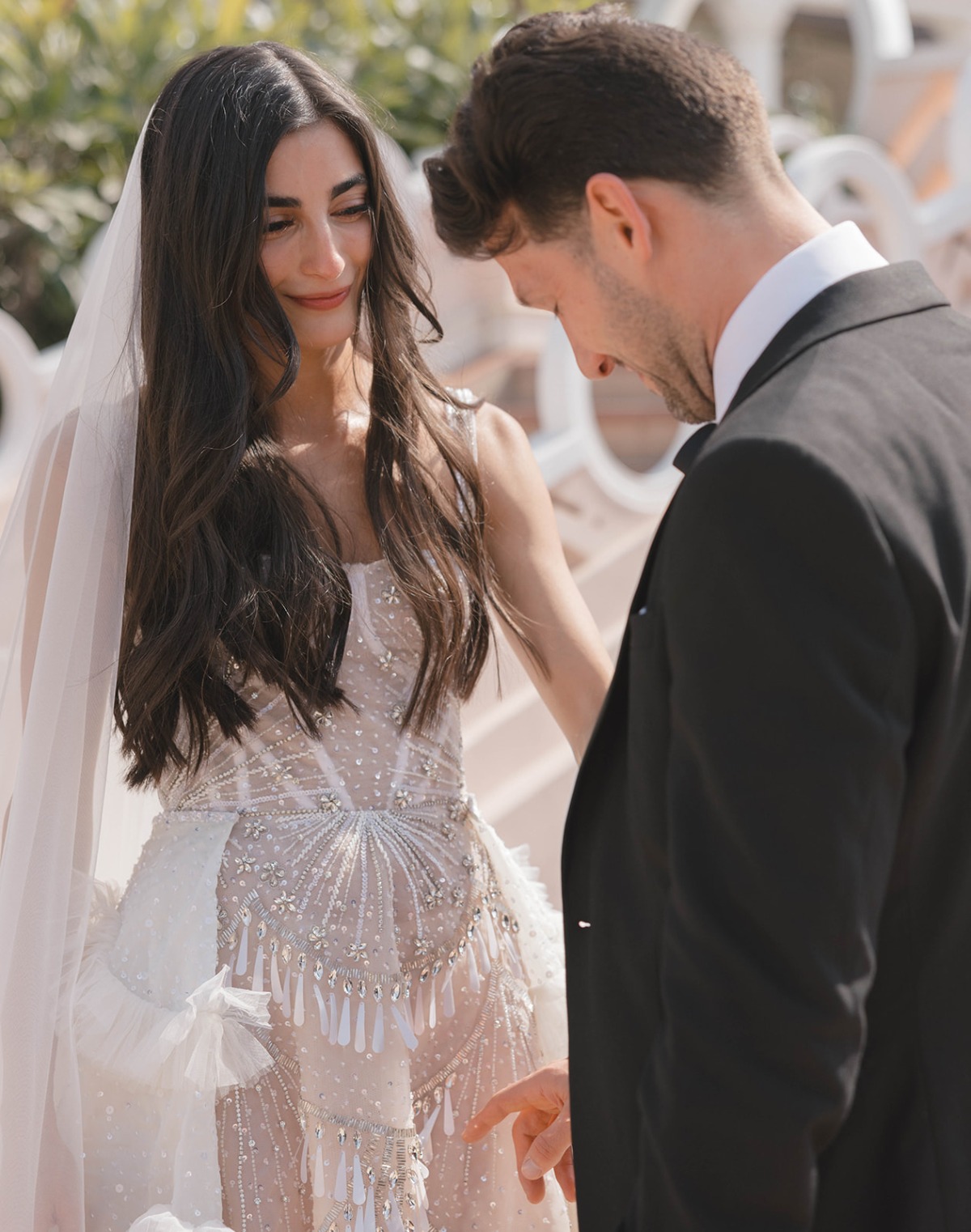 groom looking at wedding dress