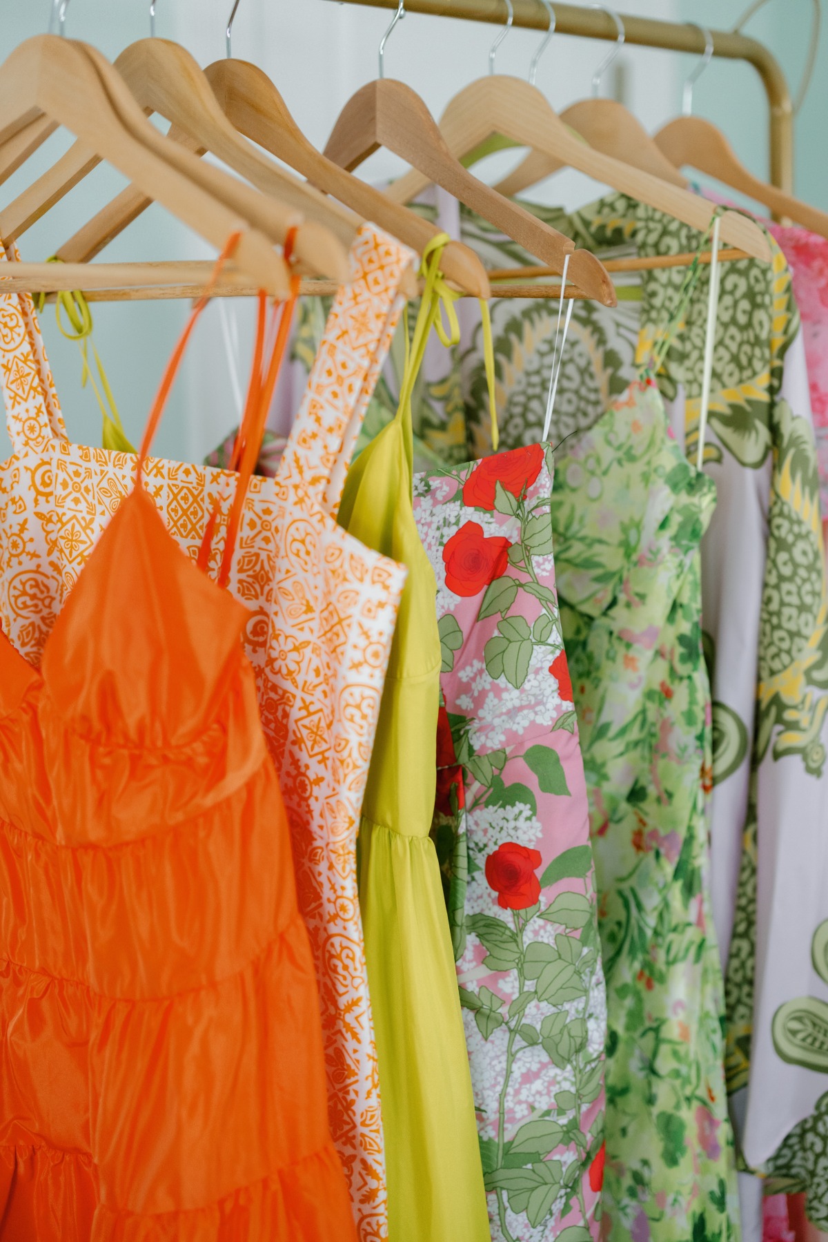mix n match colorful floral bridesmaid dresses hanging on rack