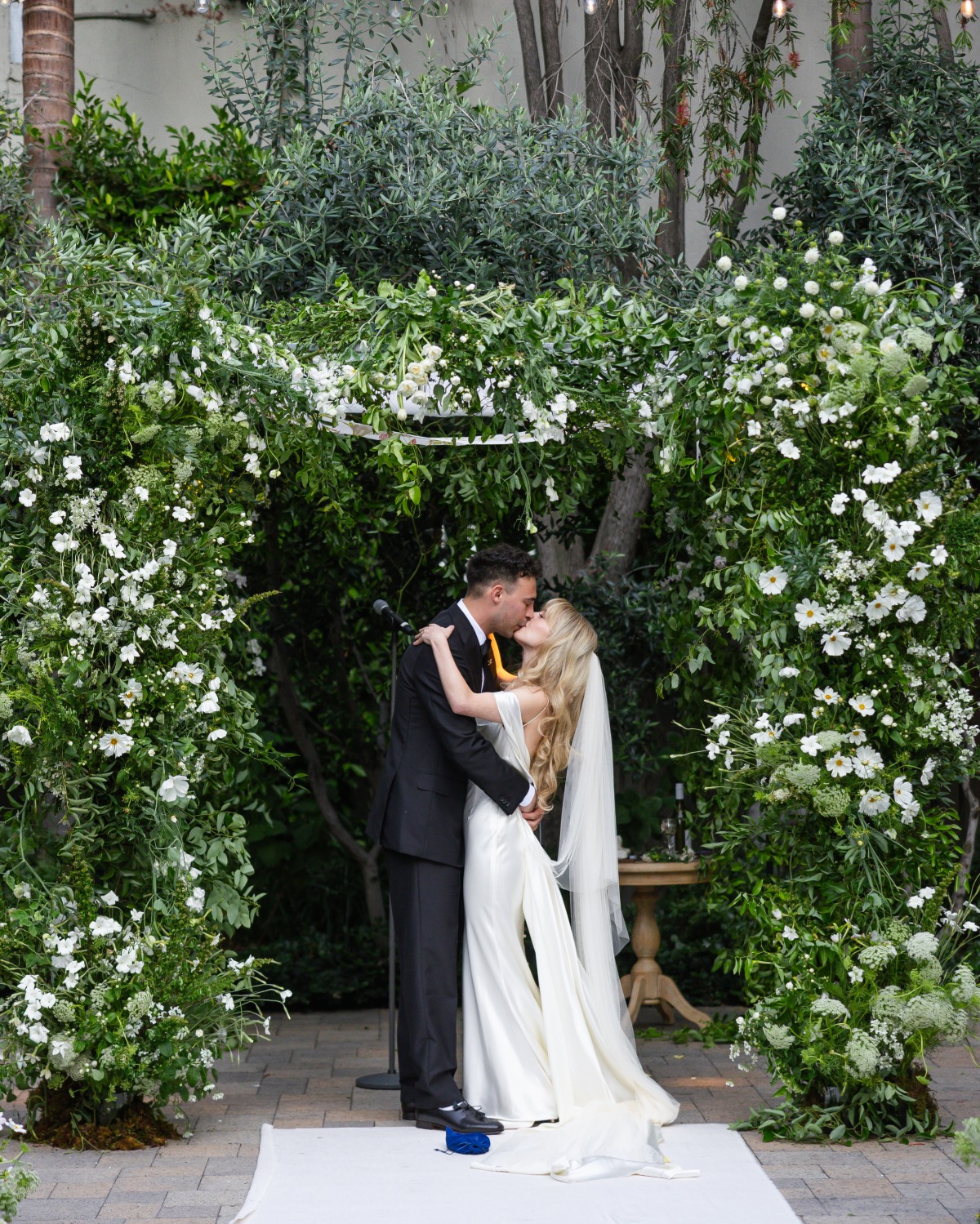 white daisy and greenery arbor