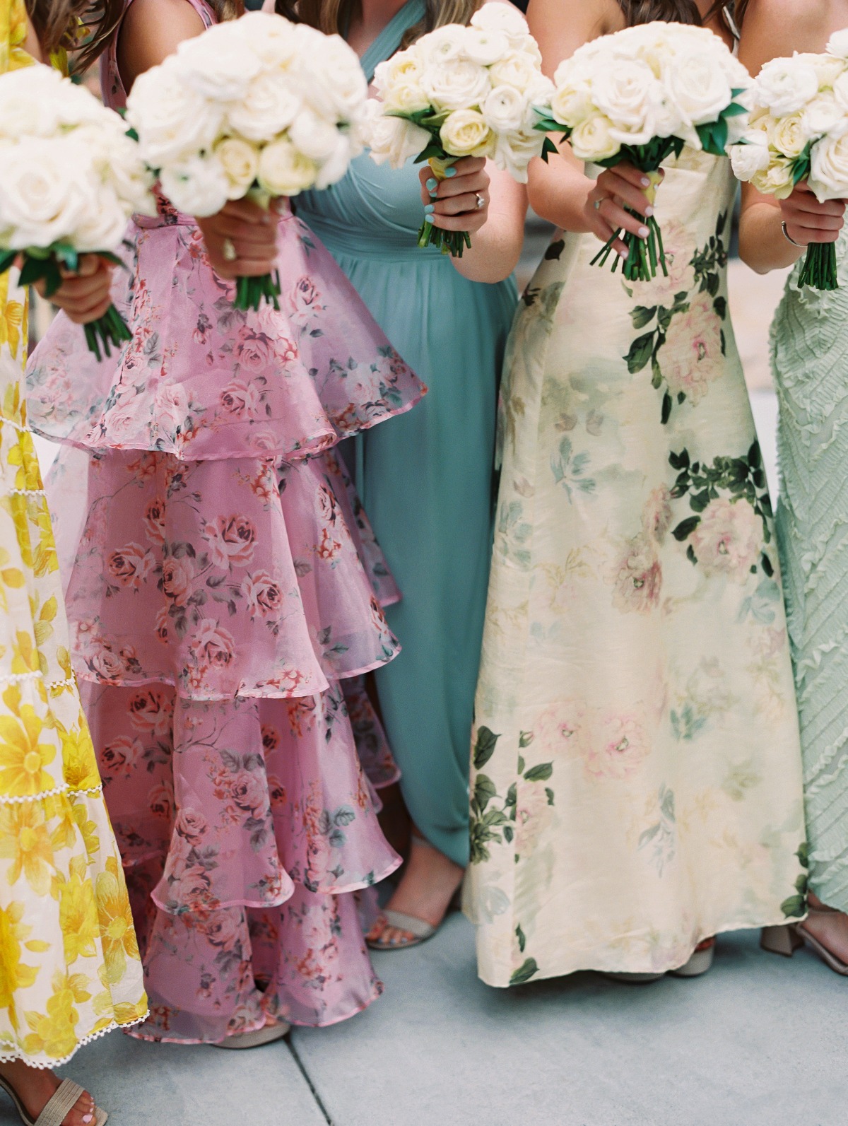 bridesmaids wearing colorful dresses with white bouquets