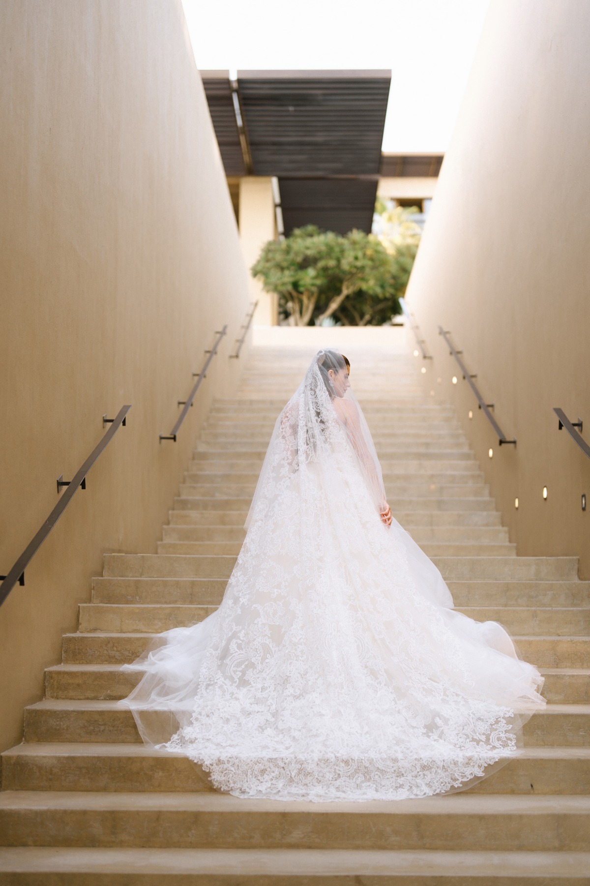 bride in dramatic wedding gown on stairs