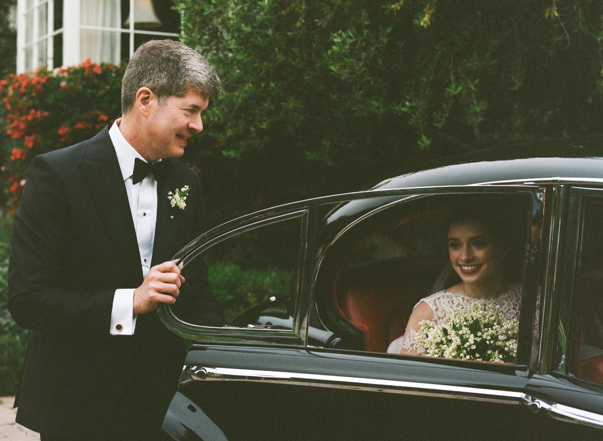 bride arrives in black vintage car