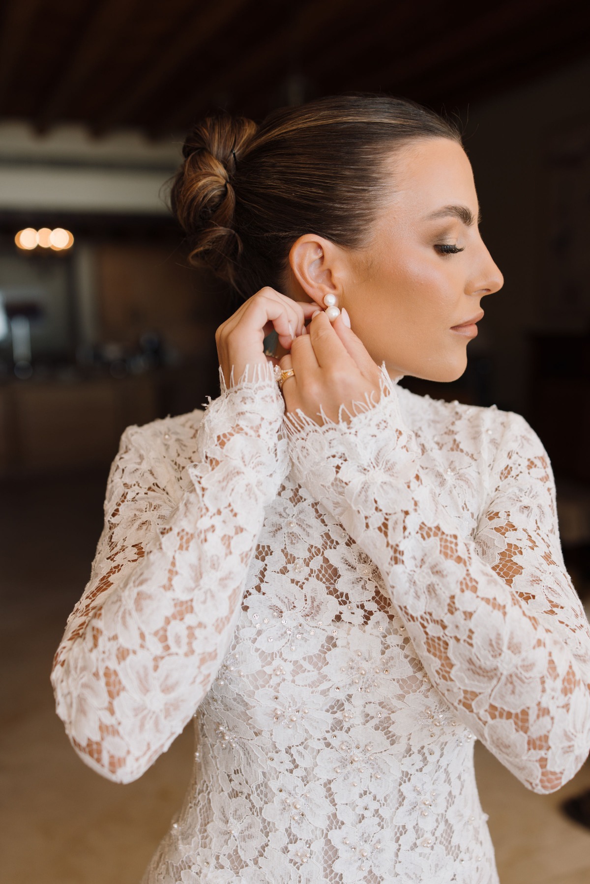 bride putting on pearl earrings