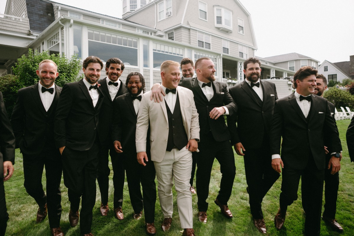 groom in tan with groomsmen in black