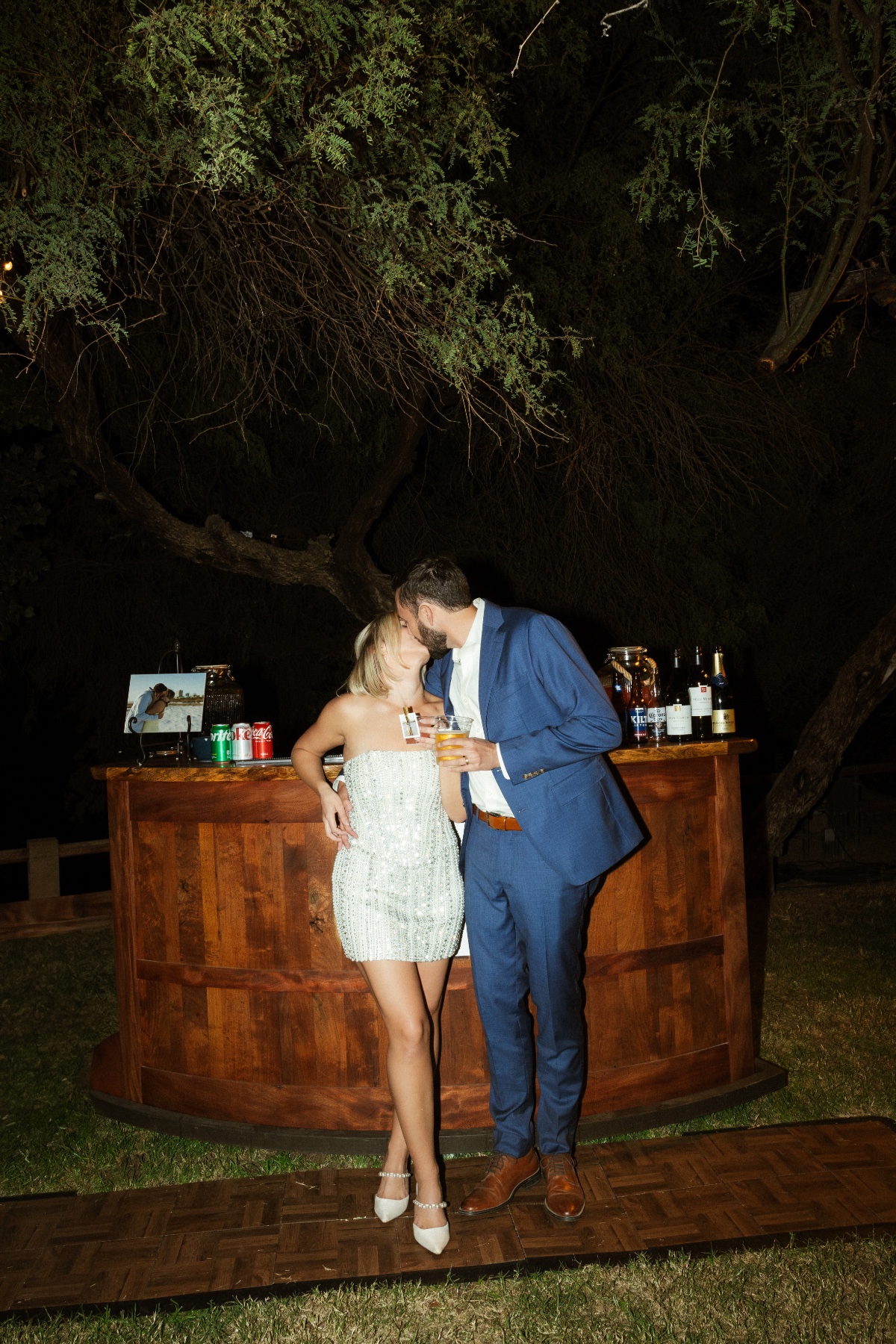 bride and groom kiss at bar