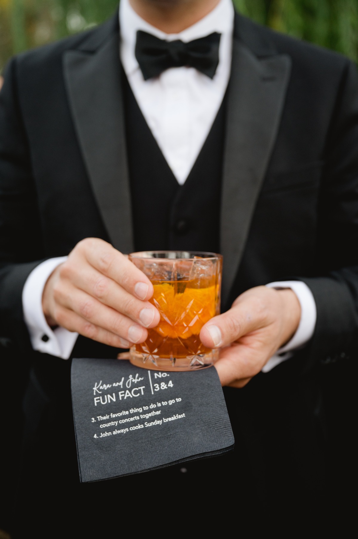 groom wearing black tux holding fancy cocktail