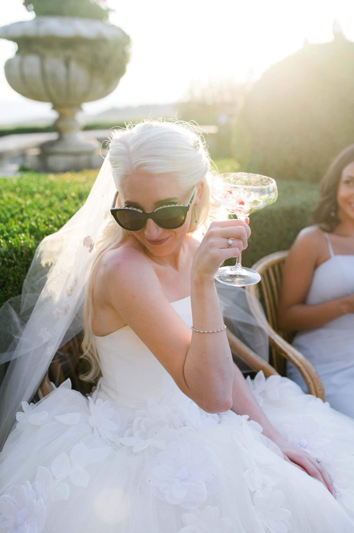 bride wearing tulle wedding dress holding up cocktail