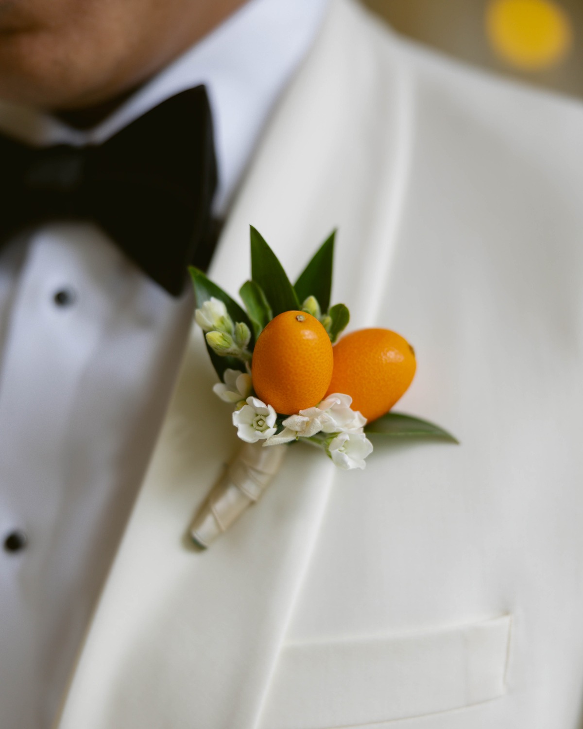 orange citrus boutonnière for groom