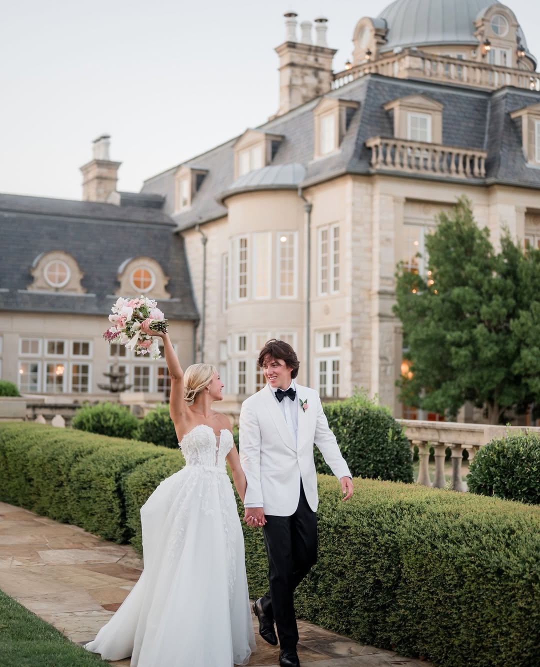couple walking holding hands in front of wedding venue