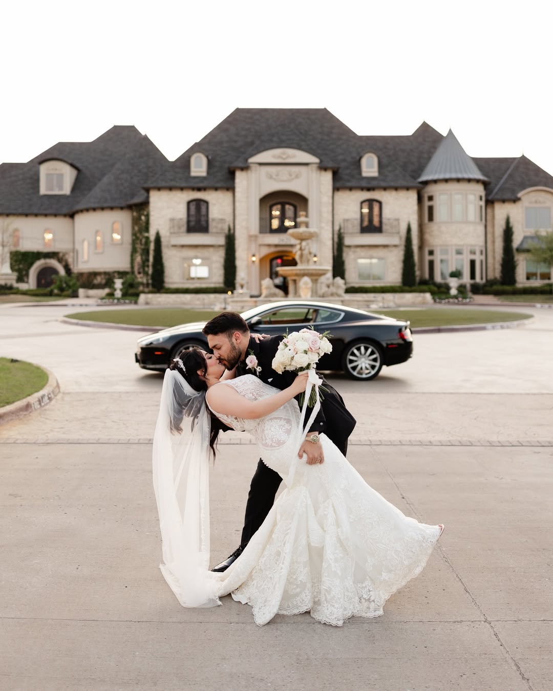 couple kissing in front of mansion