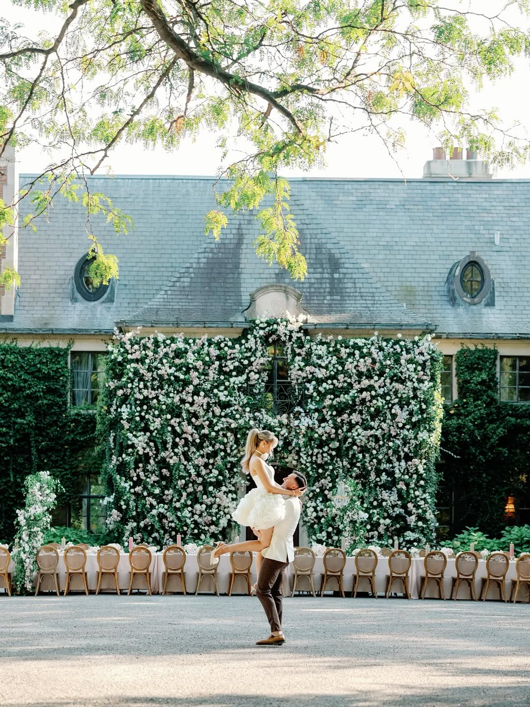 couple holding each other in front of floral wall