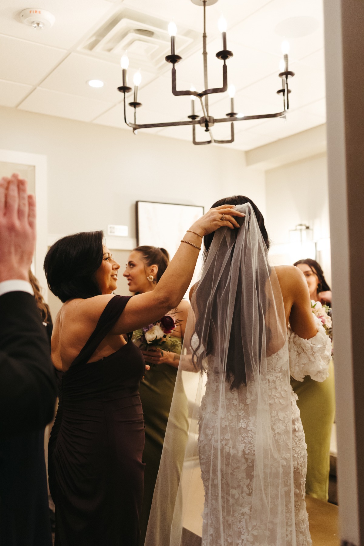 mom helping bride with veil