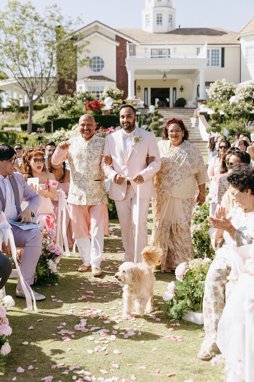 parents walking groom down the aisle