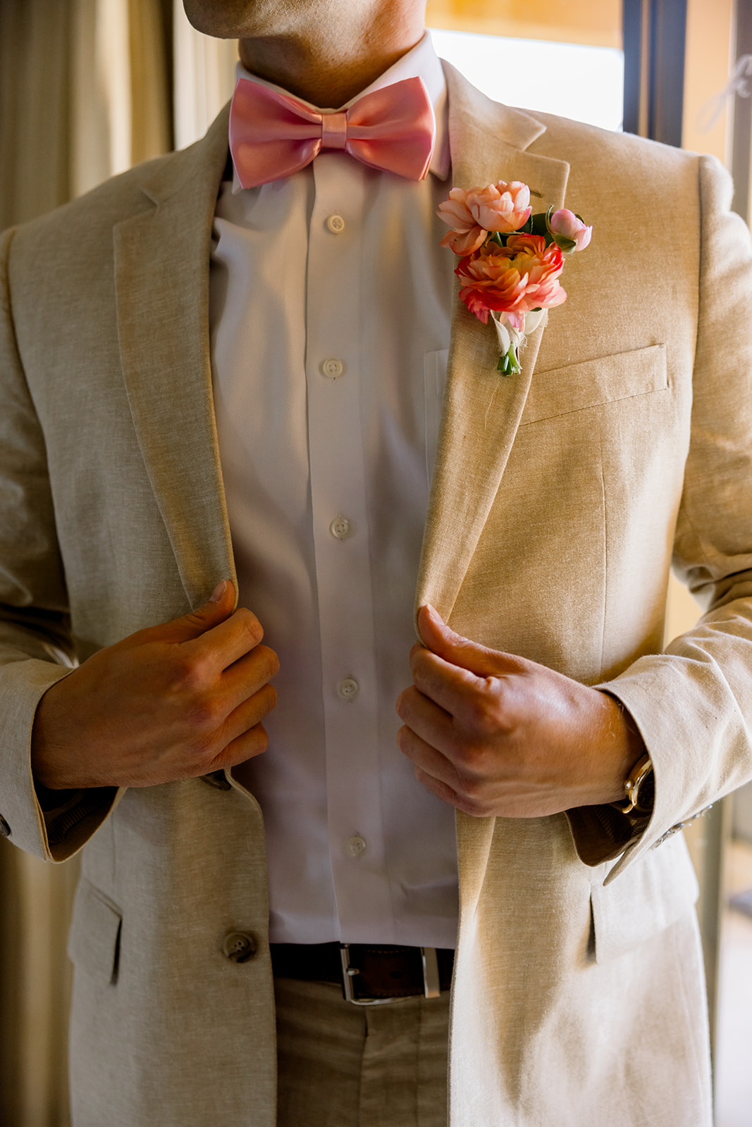 groom in linen suit with pink bow tie