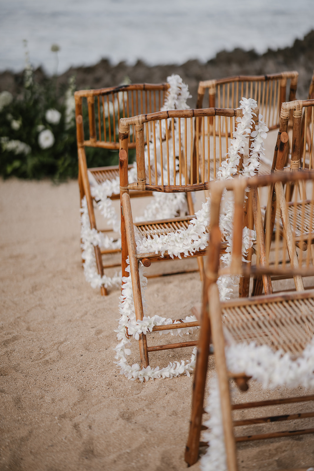white leis on chairs at wedding