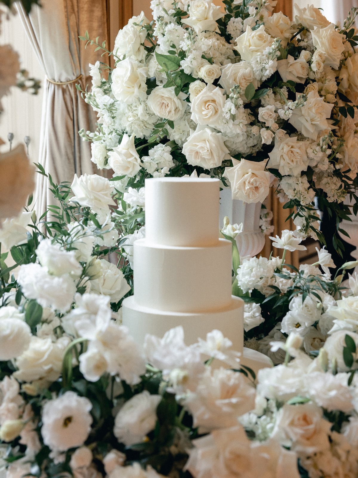 white rose covered wedding cake table