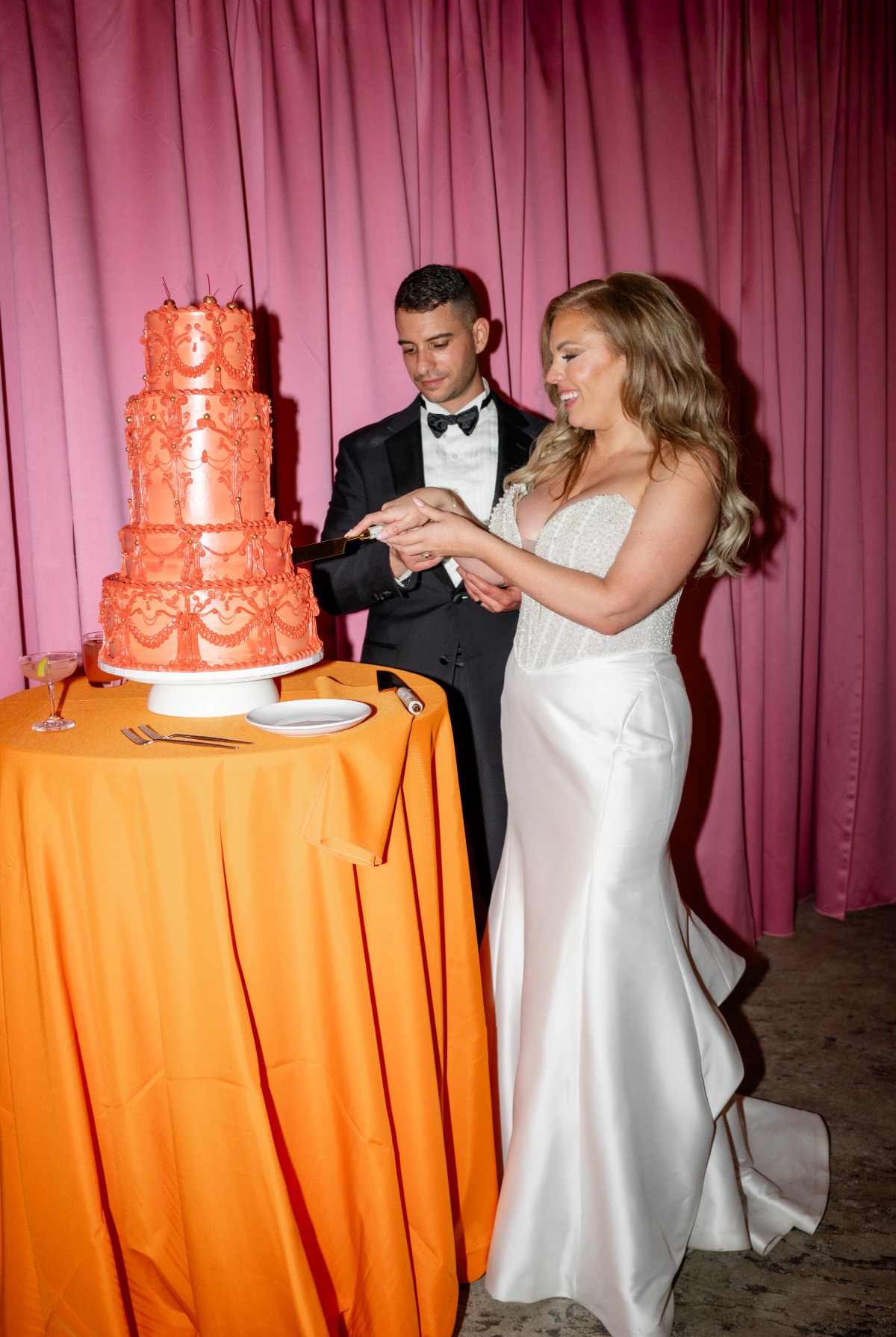 couple cutting orange wedding cake