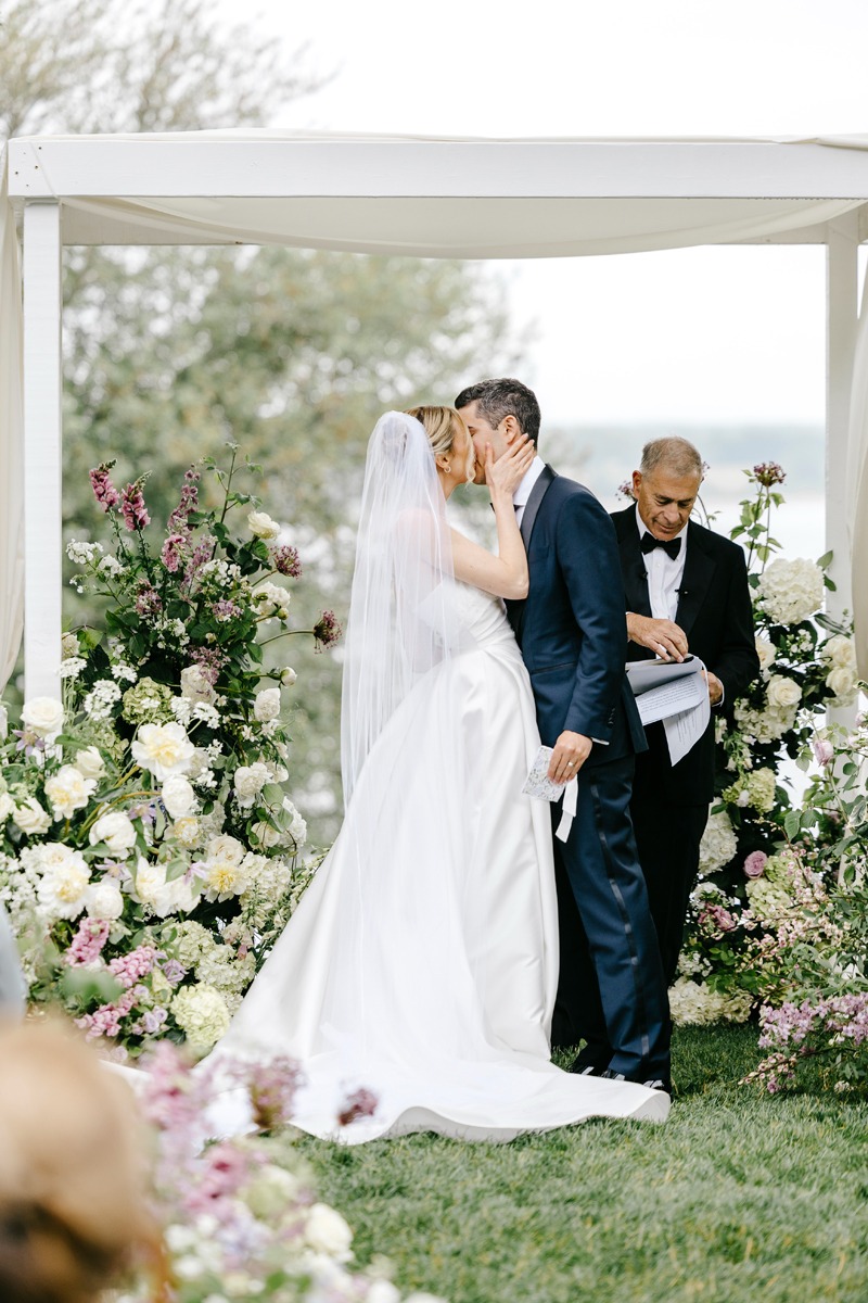 bride and groom kiss under chuppah