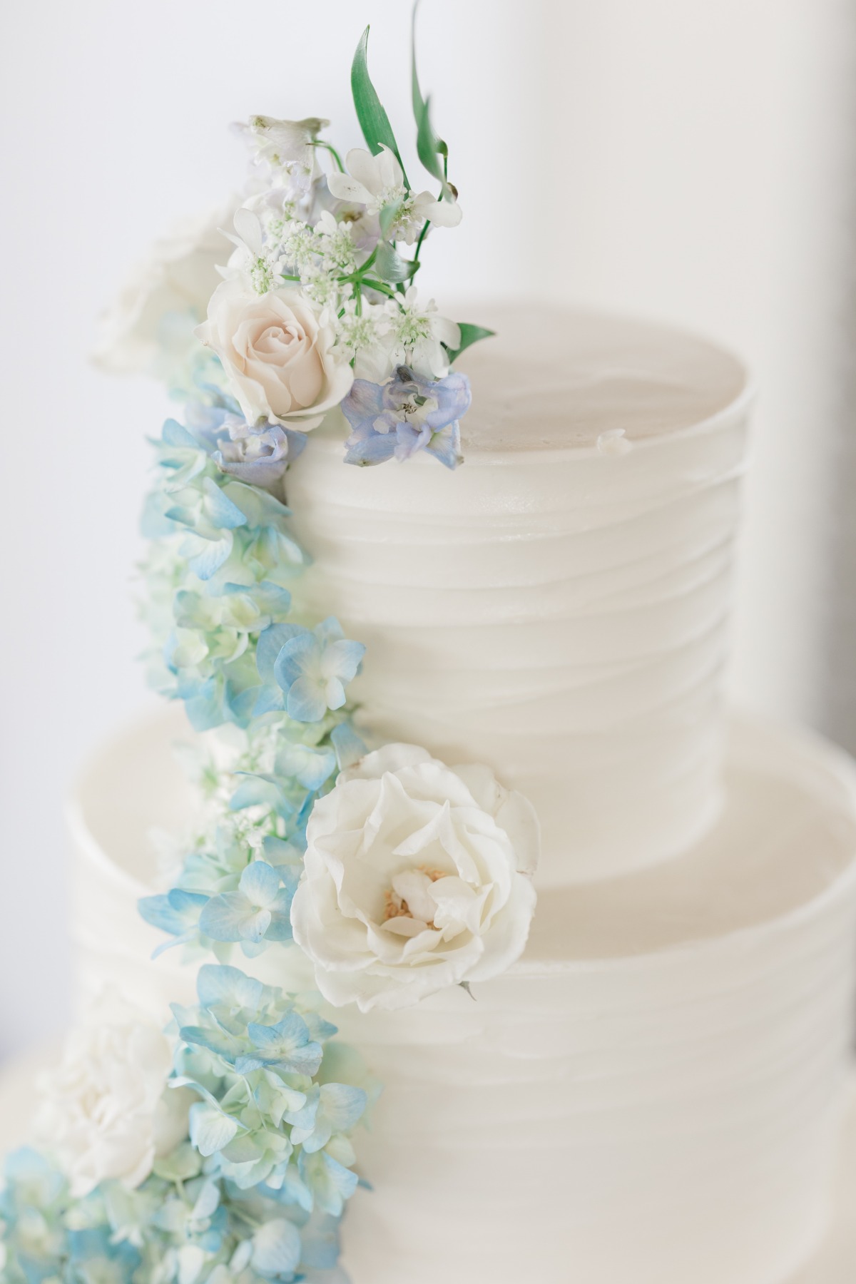 blue and white fresh flowers on wedding cake
