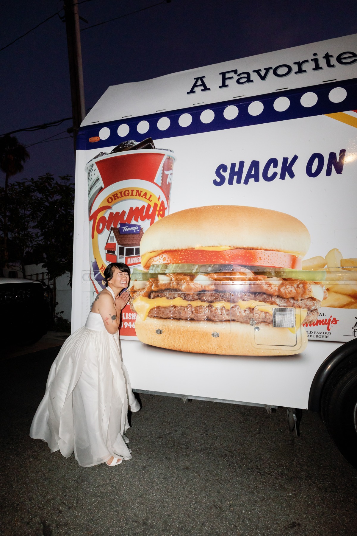 bride standing in front of burger food truck at nighttime