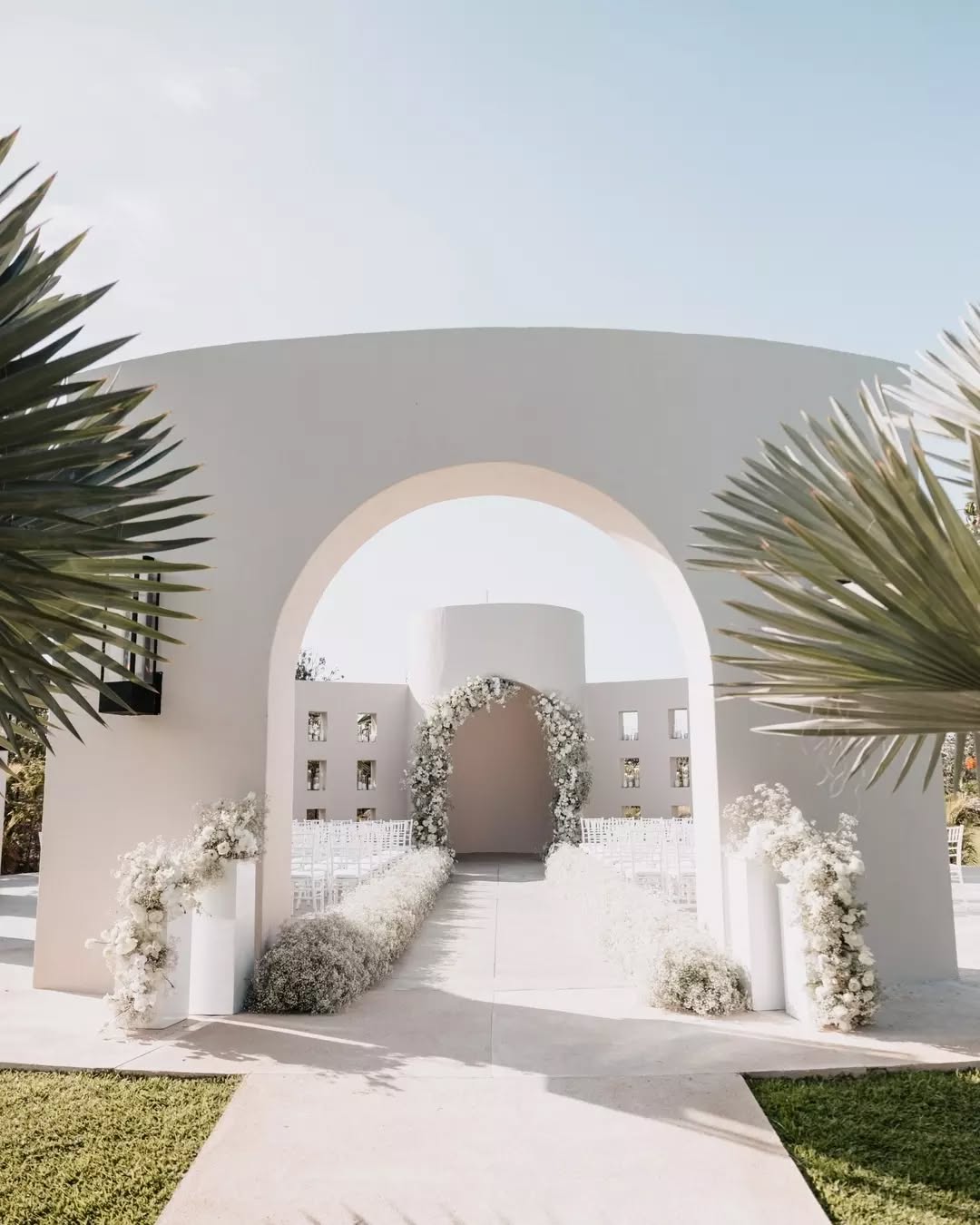 white Mexico wedding venue with clean arches and palm trees