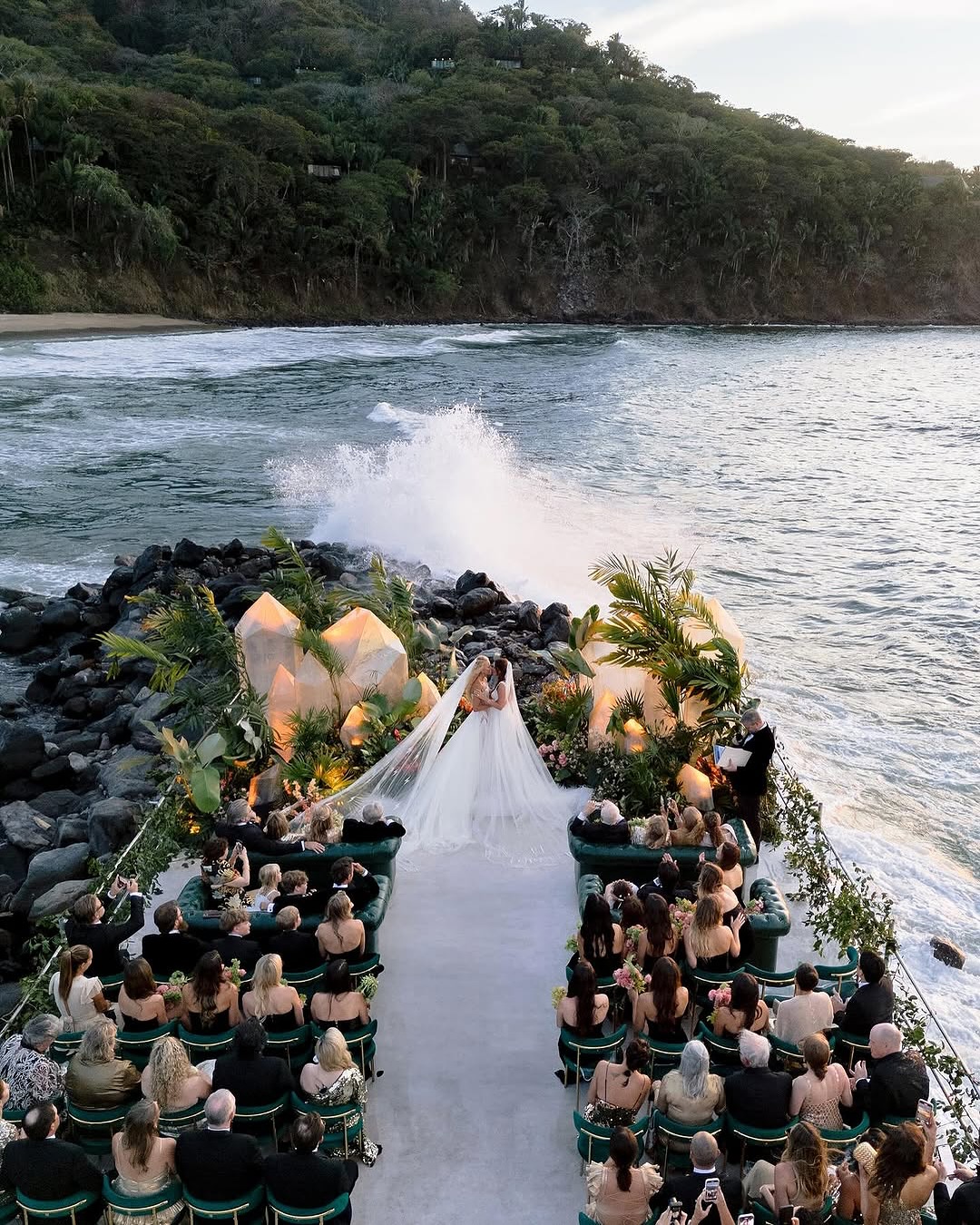 two brides kissing in a unique wedding venue on rocks in the ocean