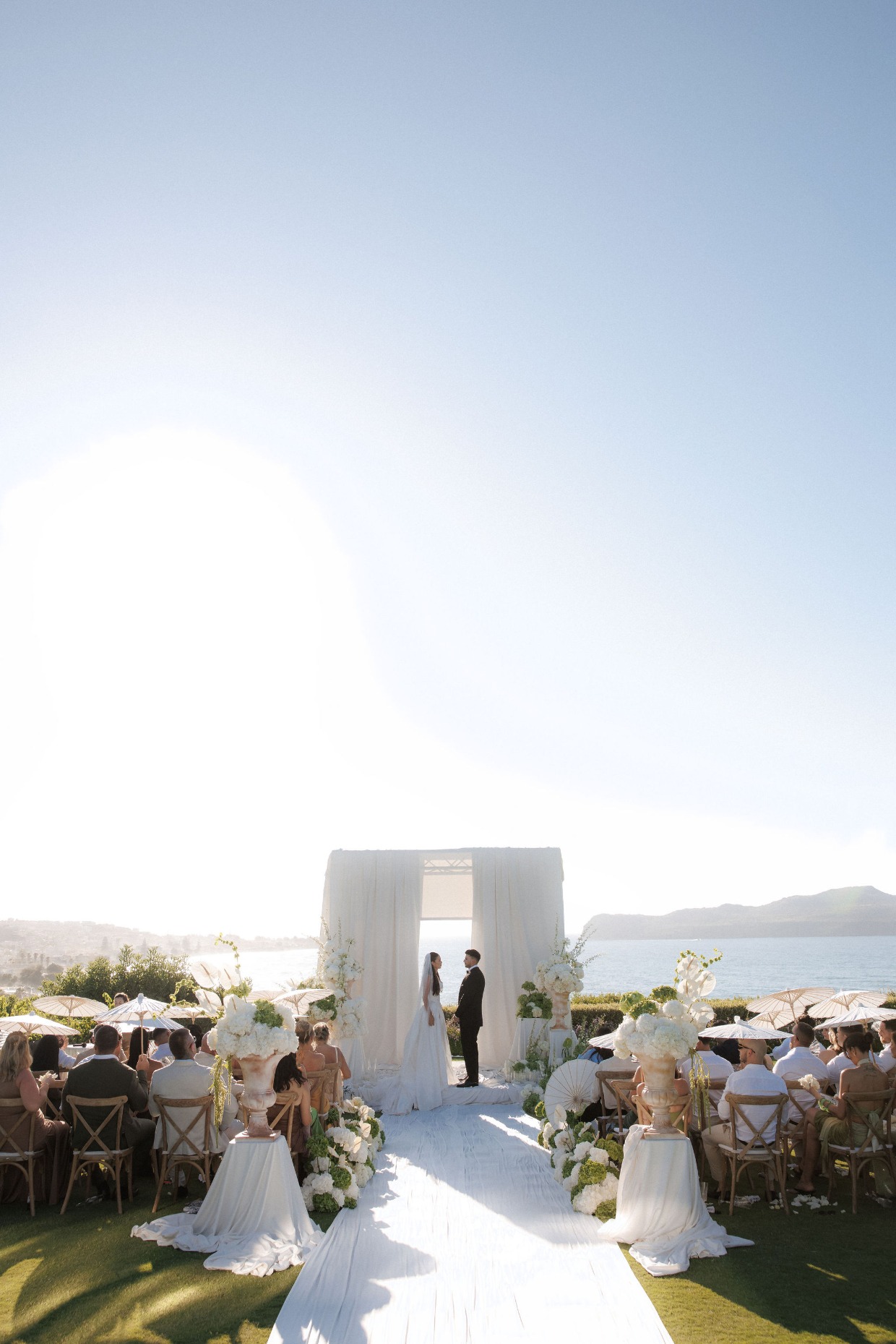 couple in outdoor wedding ceremony overlooking the ocean in crete, greece