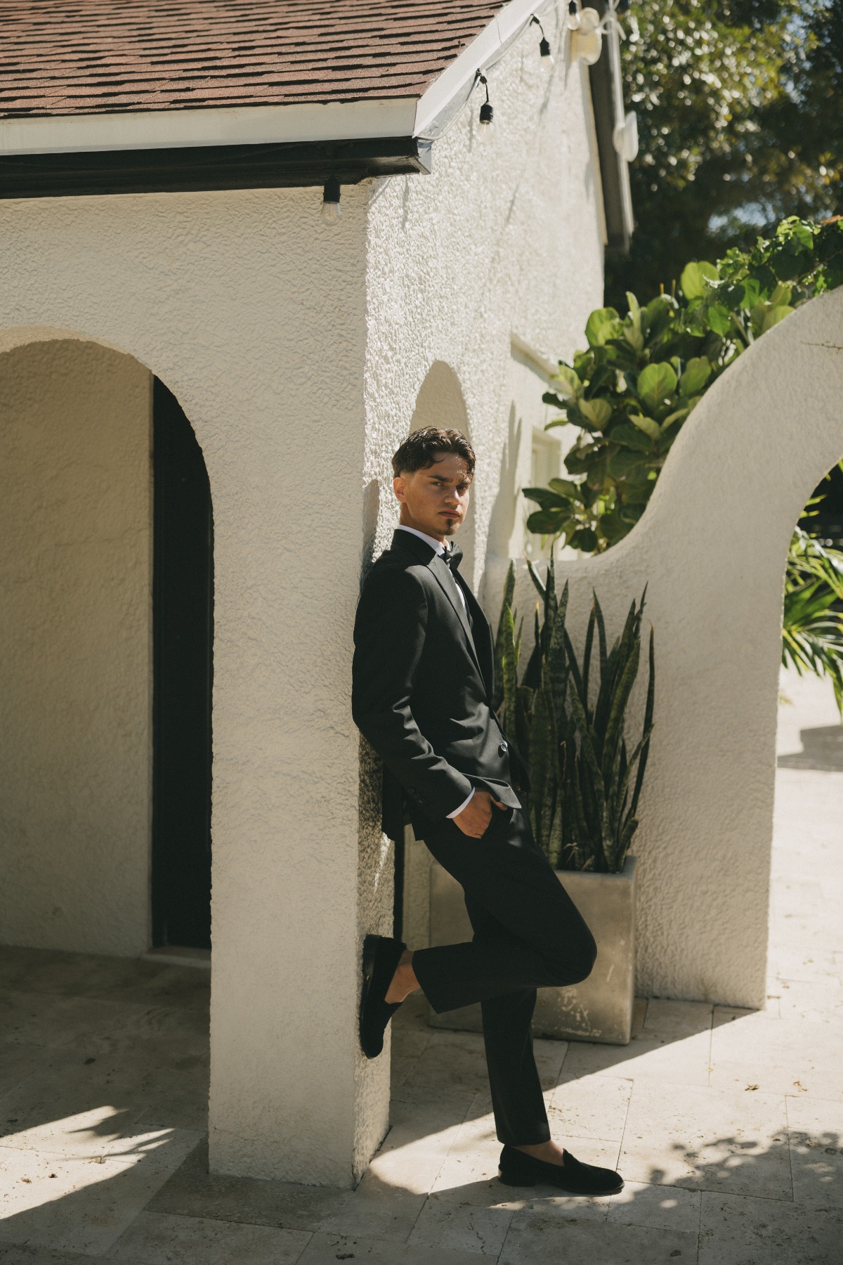Slavic Groom Standing Against Wedding Venue in Fort Meyers in the Sunlight