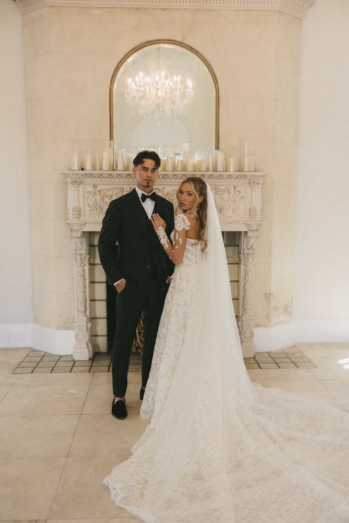 slavic wedding couple standing in front of vintage fireplace with hurricane candles
