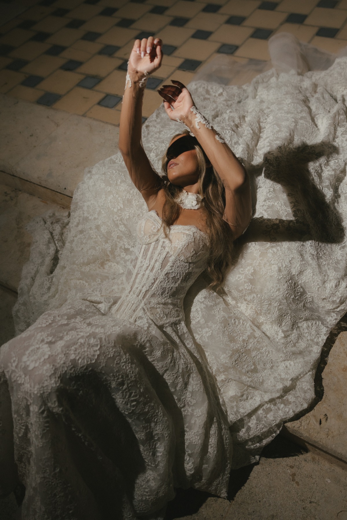 bride laying on ground with lace wedding dress around her