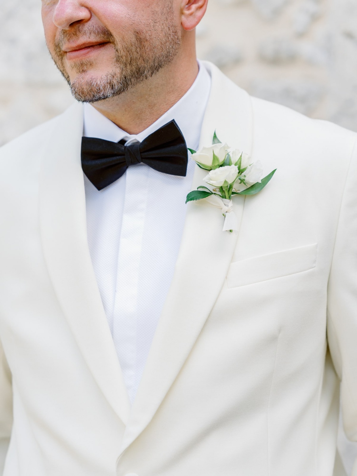groom in white dinner jacket for ceremony