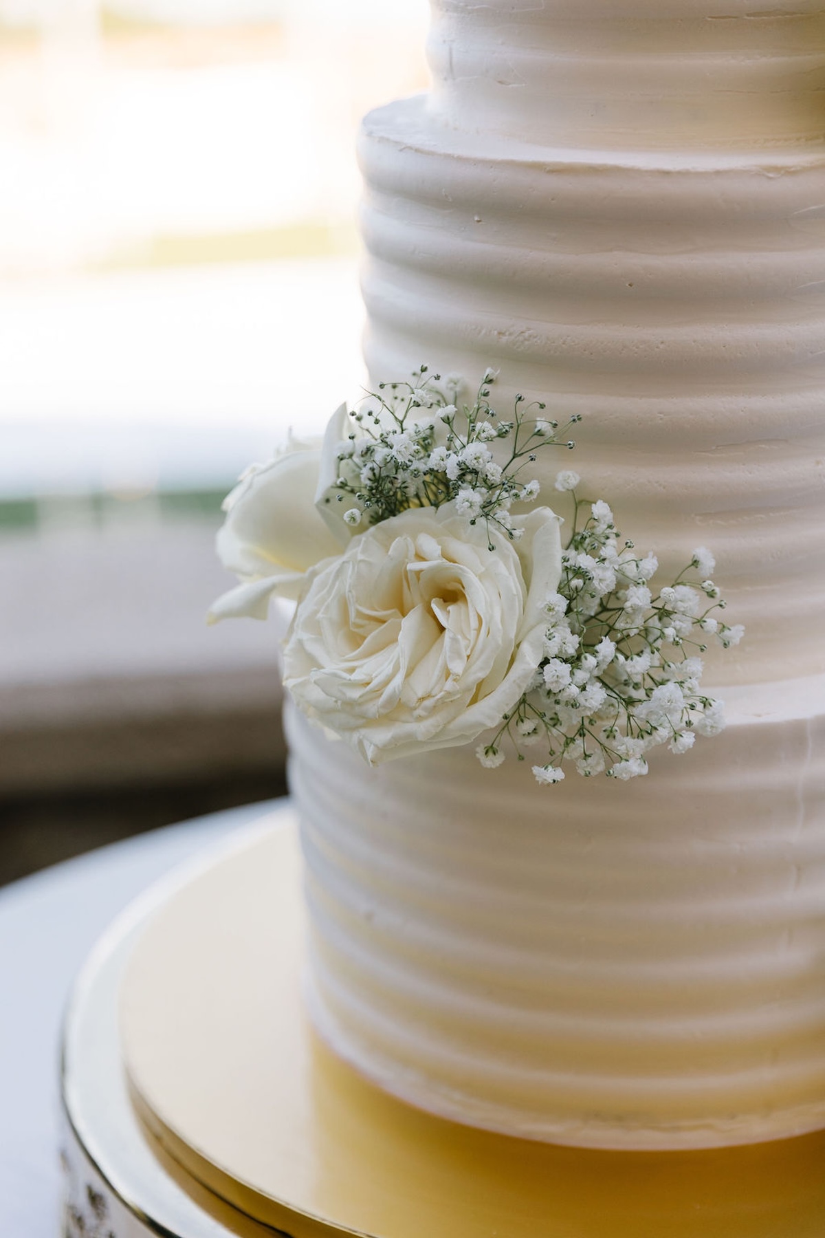 simple buttercream frosted wedding cake with fresh flowers