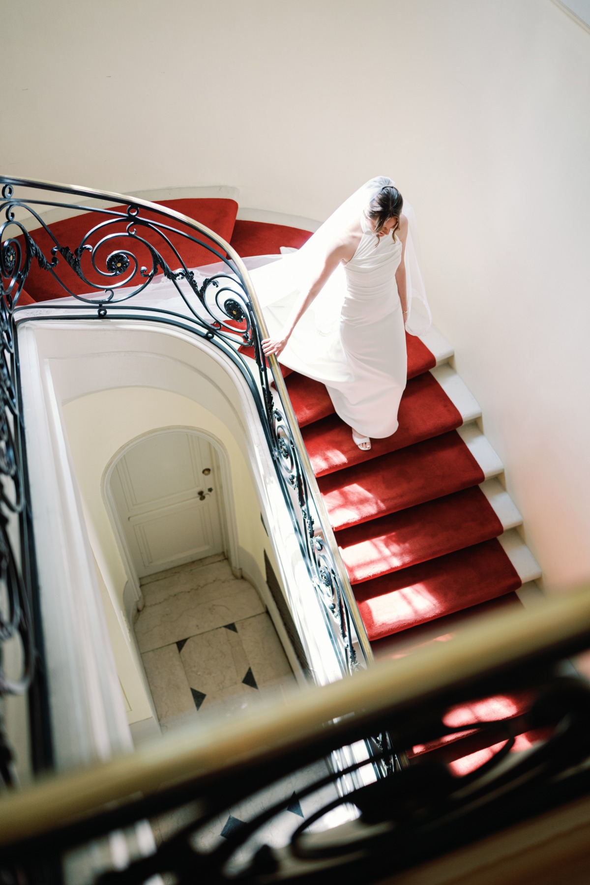 bride walking down red staircase