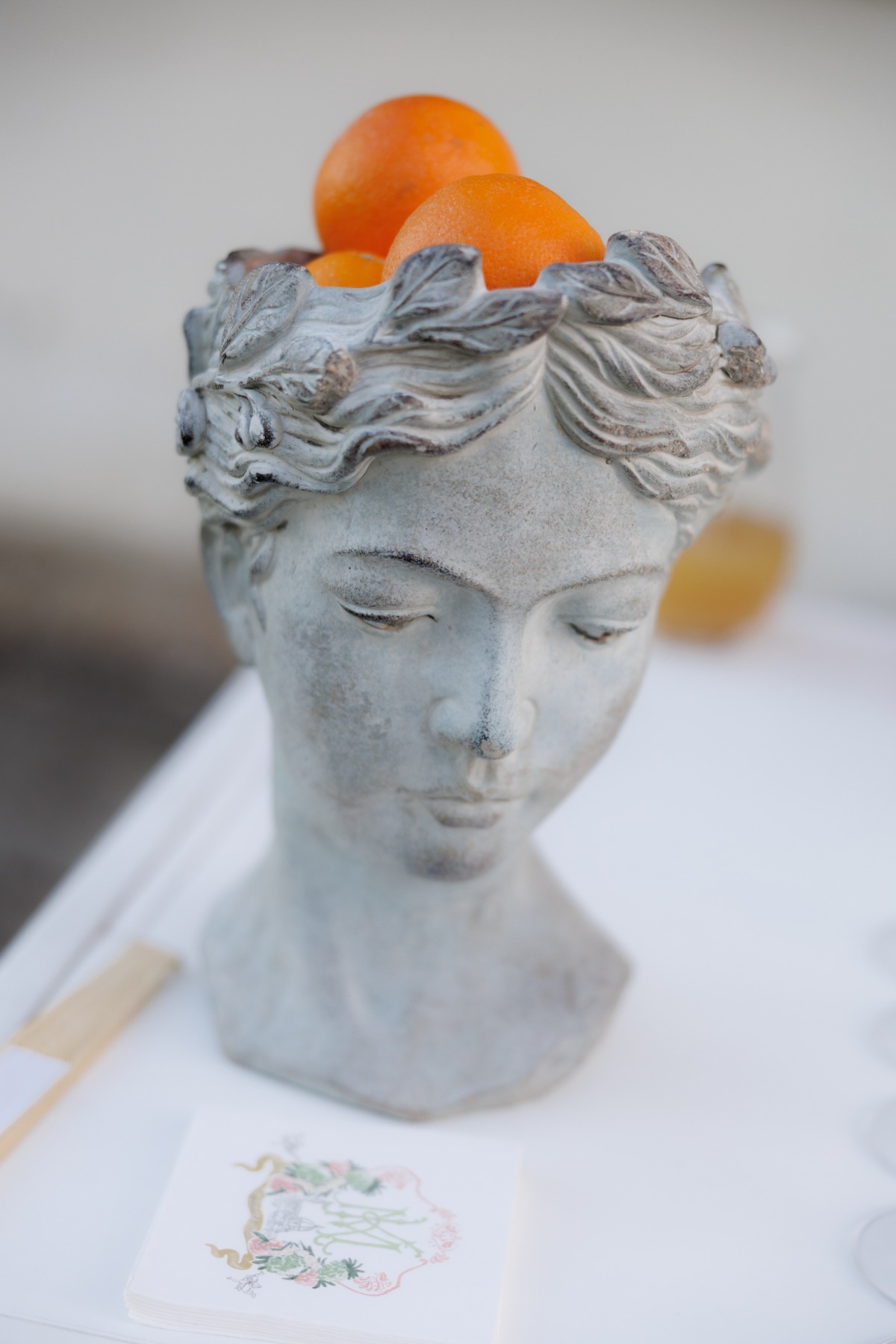 statue head holding oranges 