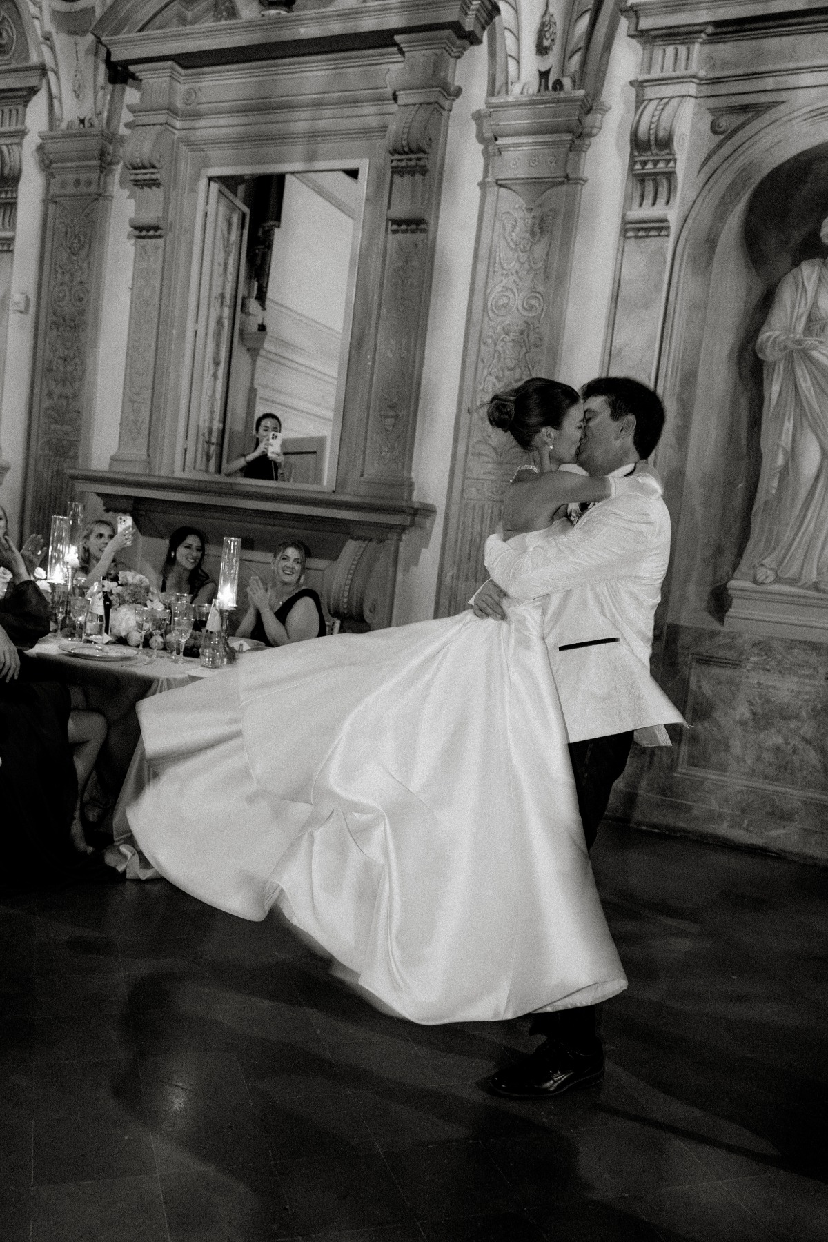 black and white photo of bride and groom dancing and kissing 