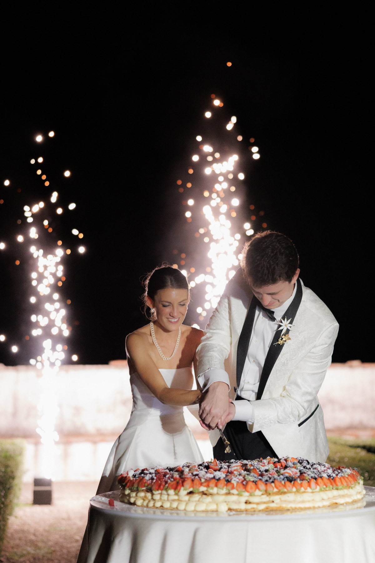bride and groom doing a traditional italian cake cutting with cold sparklers