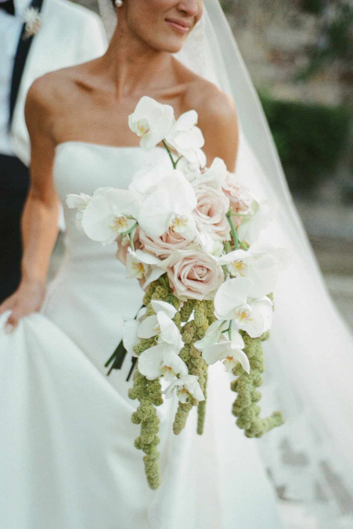 stunning shot of bride holding bouquet of orchids and soft pink roses